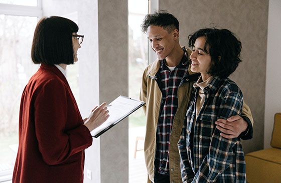 A young couple is ready to sign a mortgage document after having the terms explained through a professional interpreter.