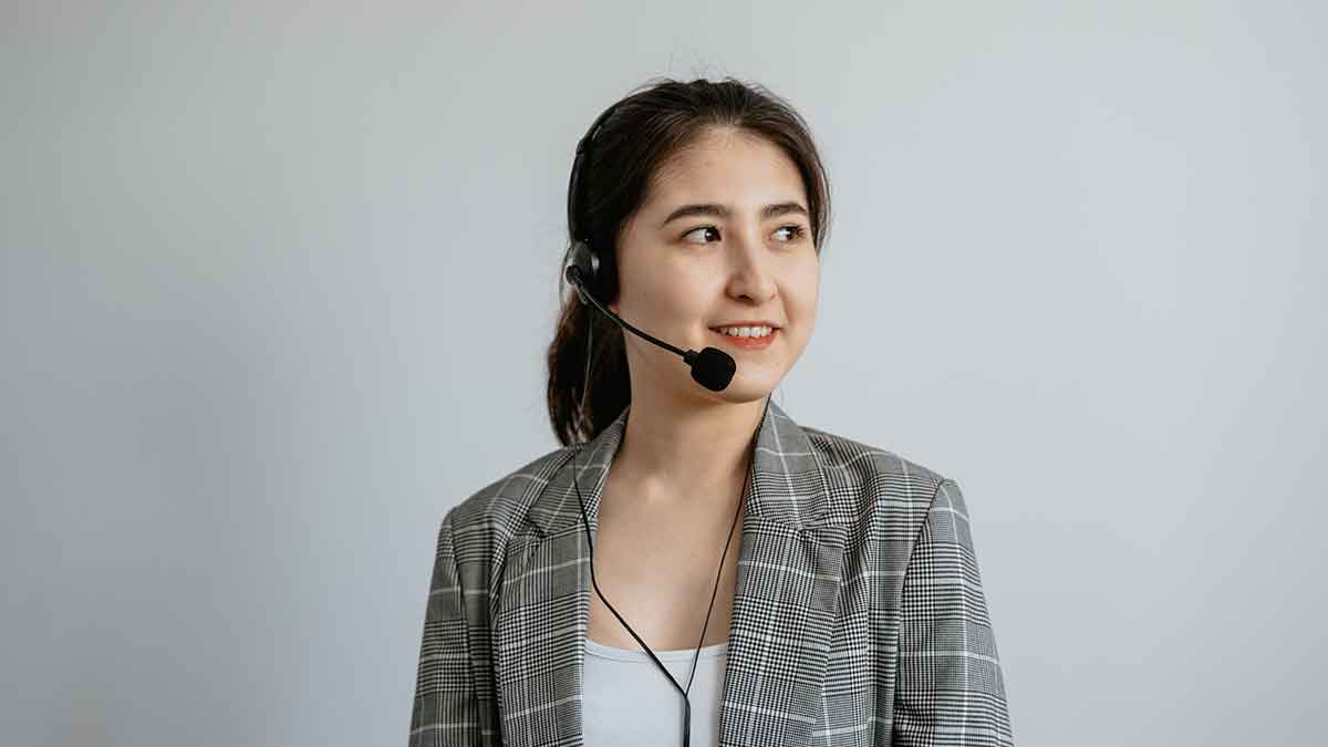 Female interpreter wearing headset looking to her left and smiling.