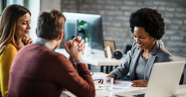 A financial advisor laughs with a new borrower.