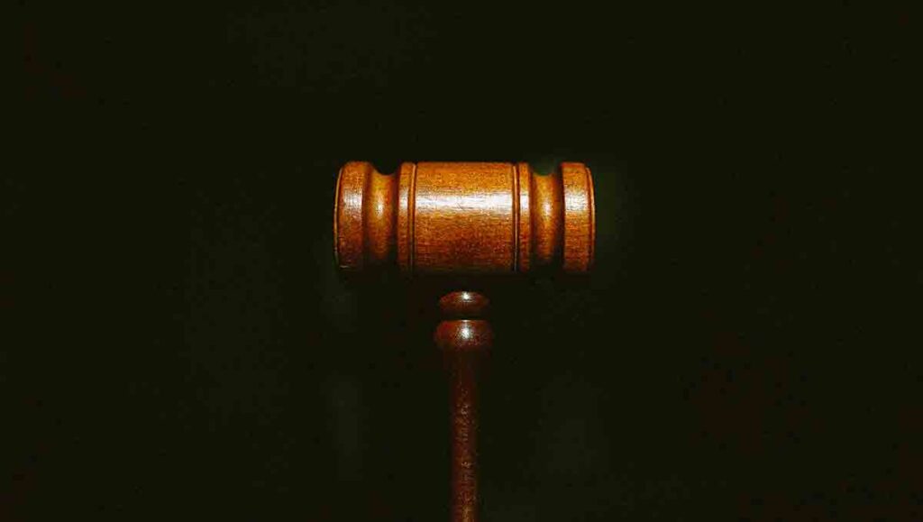 Close up of brown gavel on a black background.
