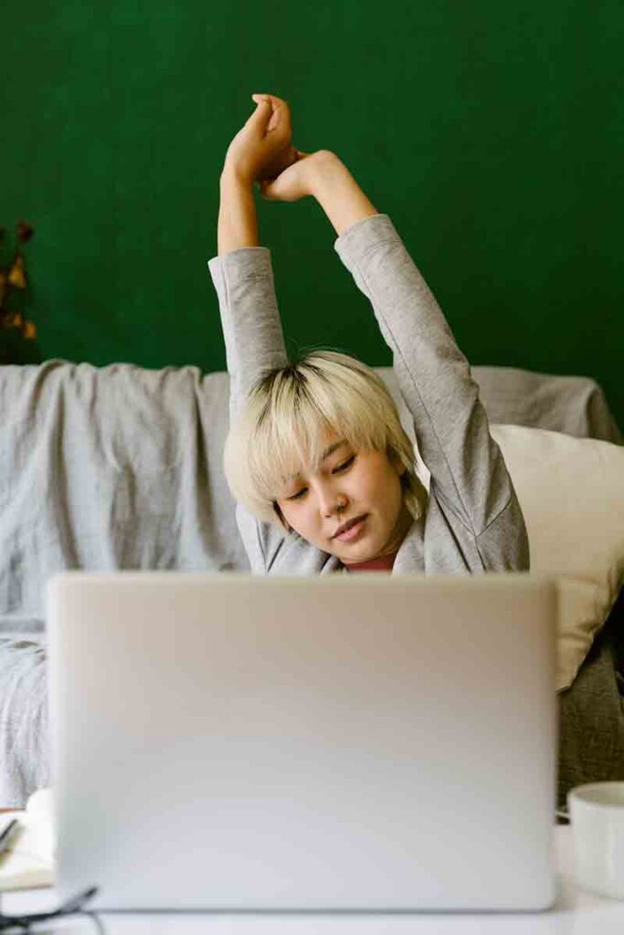 Female interpreter stretching in between remote calls to prevent emotional burnout