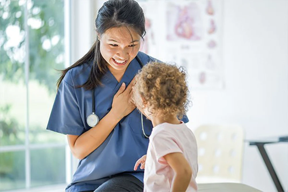 A compassionate doctor finishes a toddler's medical appointment with the help of an interpreter.