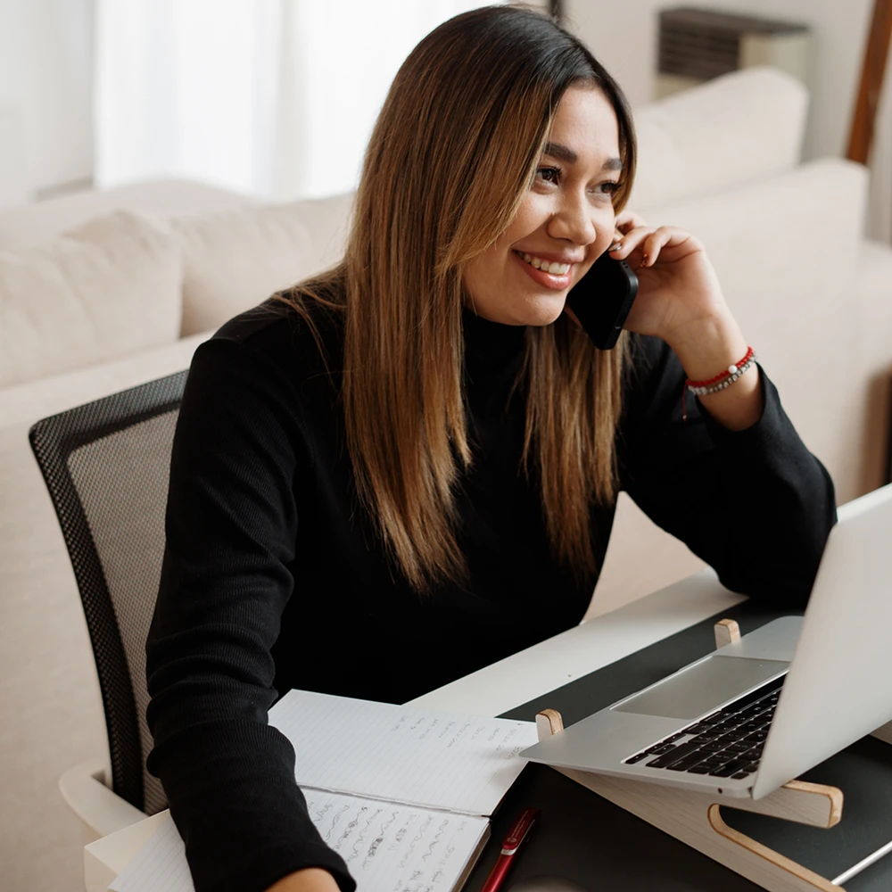 A caseworker speaks to a family on the phone with the help of a Haitian Creole interpreter.